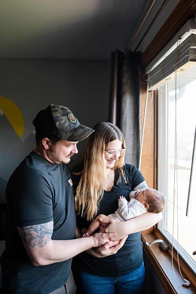 dad and mom by window with boy