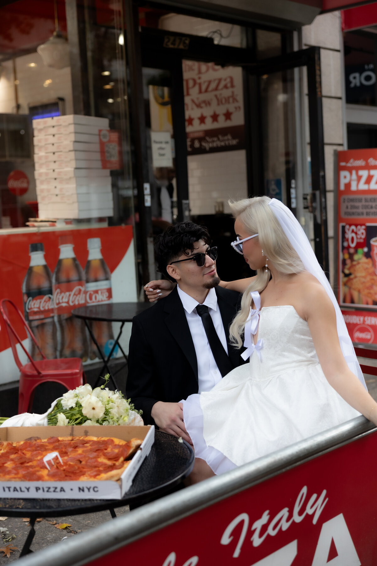 Candid shot of the couple laughing while eating pizza at their NYC elopement celebration.