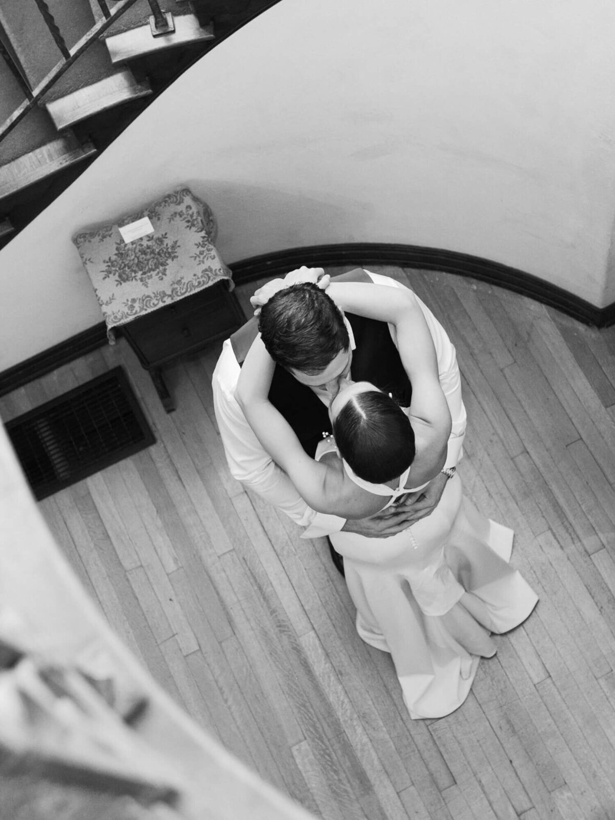 different angle of bride and groom dancing under the stairs at Muckenthaler Mansion