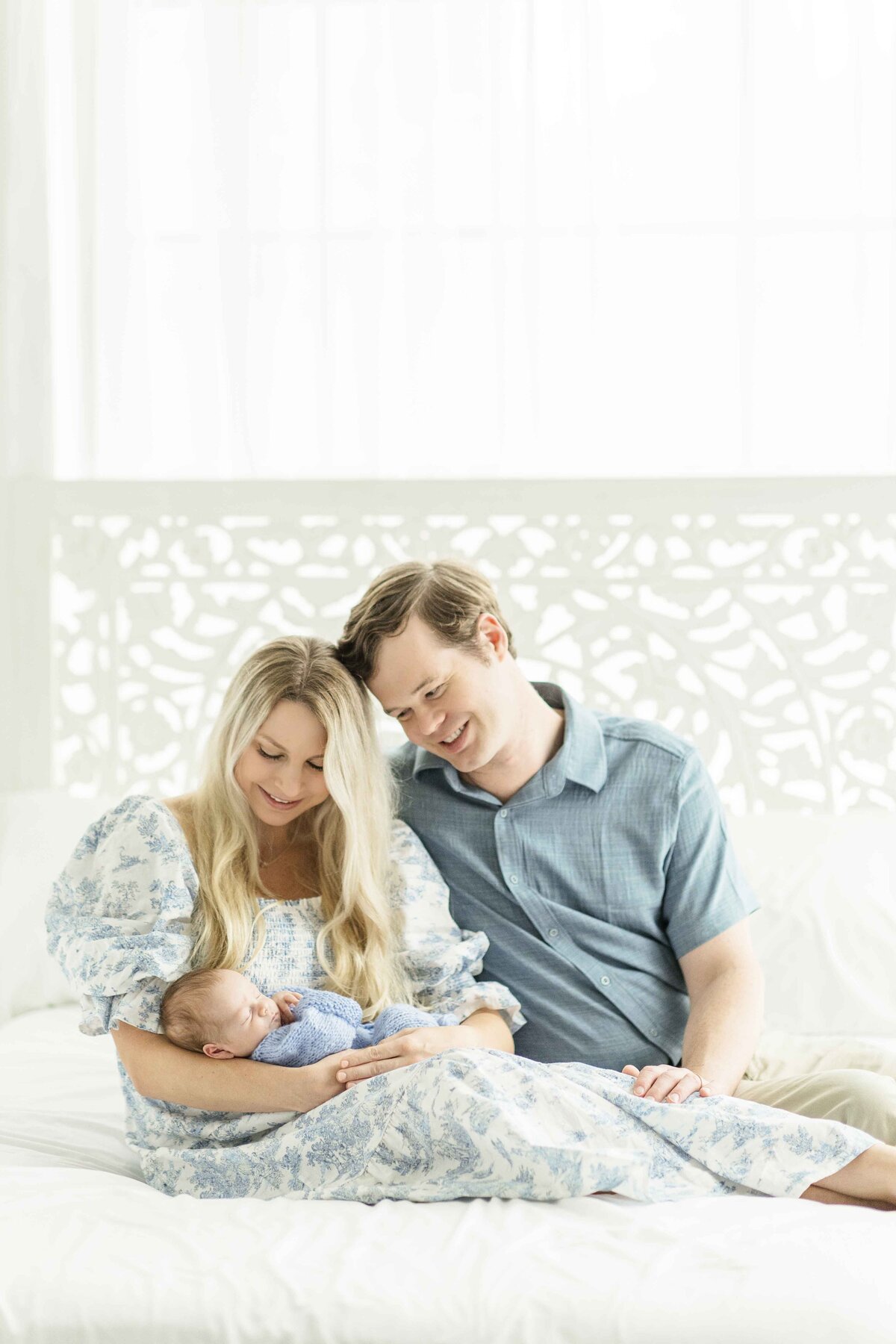 mom dad and baby all snuggle together on studio bed in houston 
