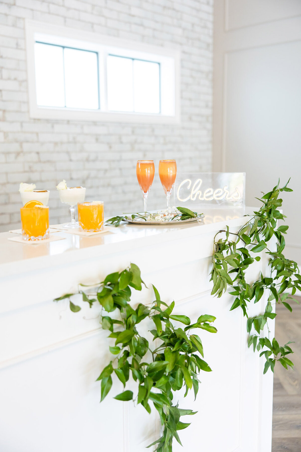 Wedding reception bar beautifully decorated with greenery and right drinks