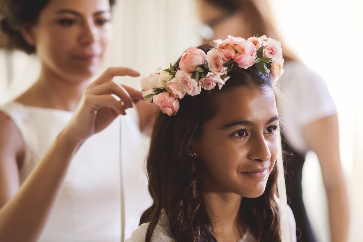 Bride putting on rose crown on flower girl at wedding in Riviera Maya