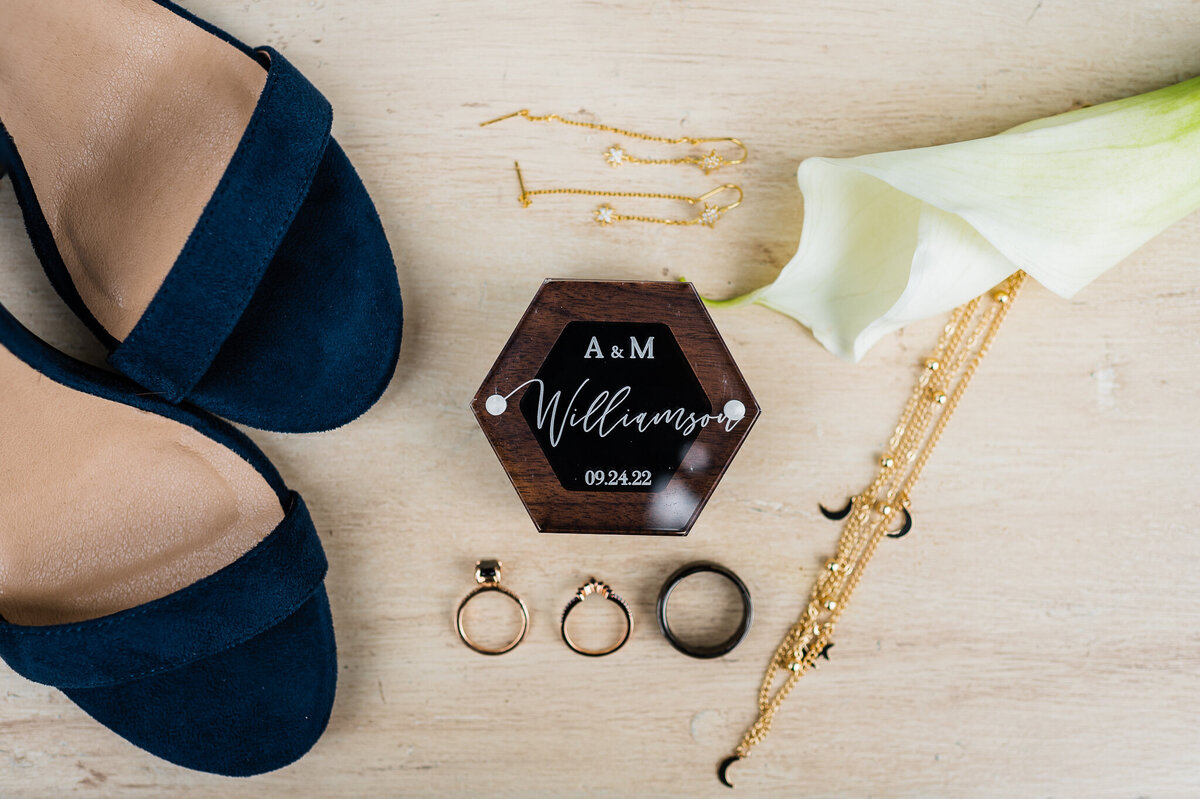 Virginia wedding photographer creates a flatlay with brides shoes, rings and florals for a detail shot that encompasses the essence of their wedding day