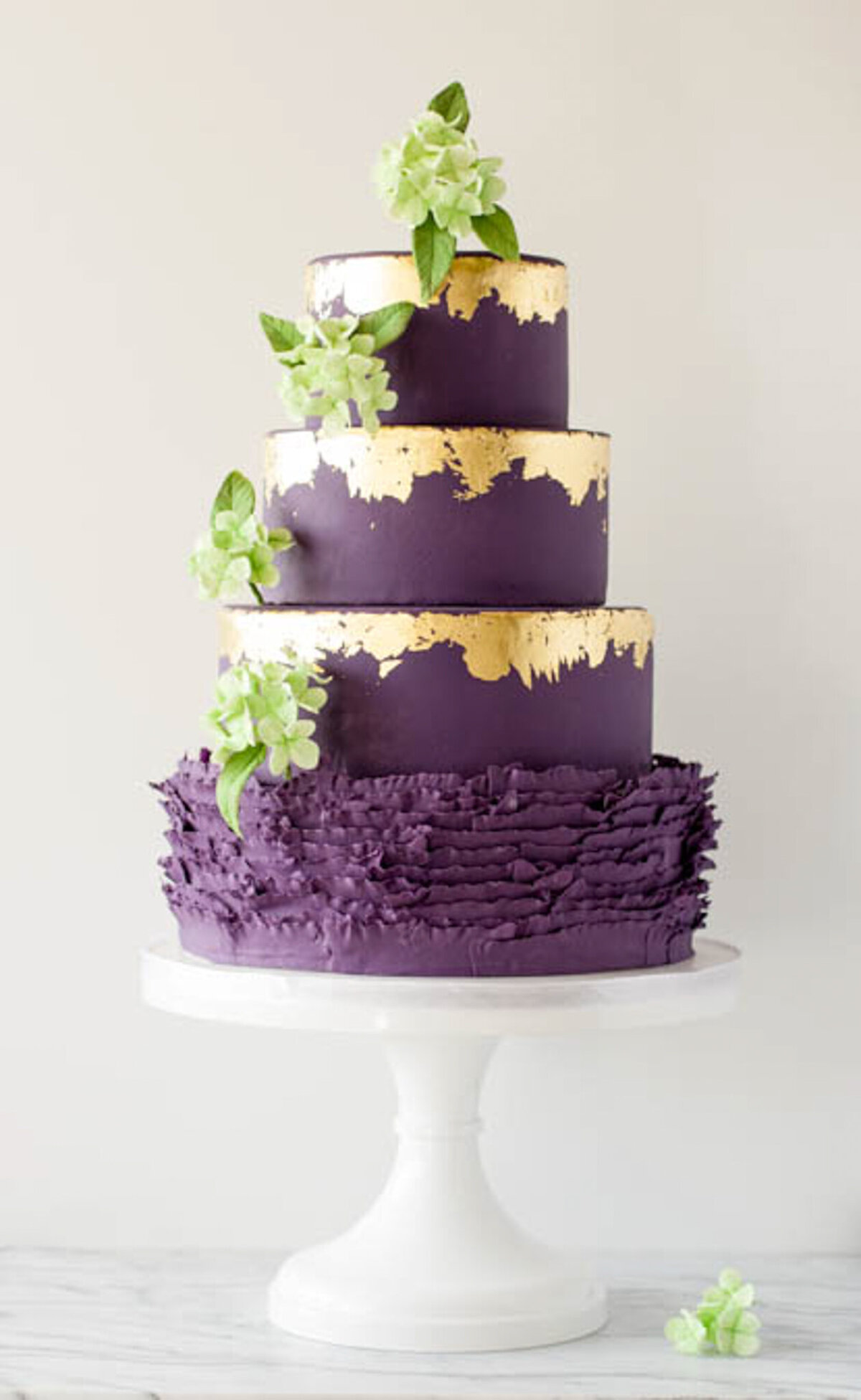 Creative purple wedding cake, decorated with gold leaf foil detail and hand crafted sugar florals, created by Brianne Gabrielle Cakes,  elegant cakes & desserts in Edmonton, AB, featured on the Brontë Bride Vendor Guide.