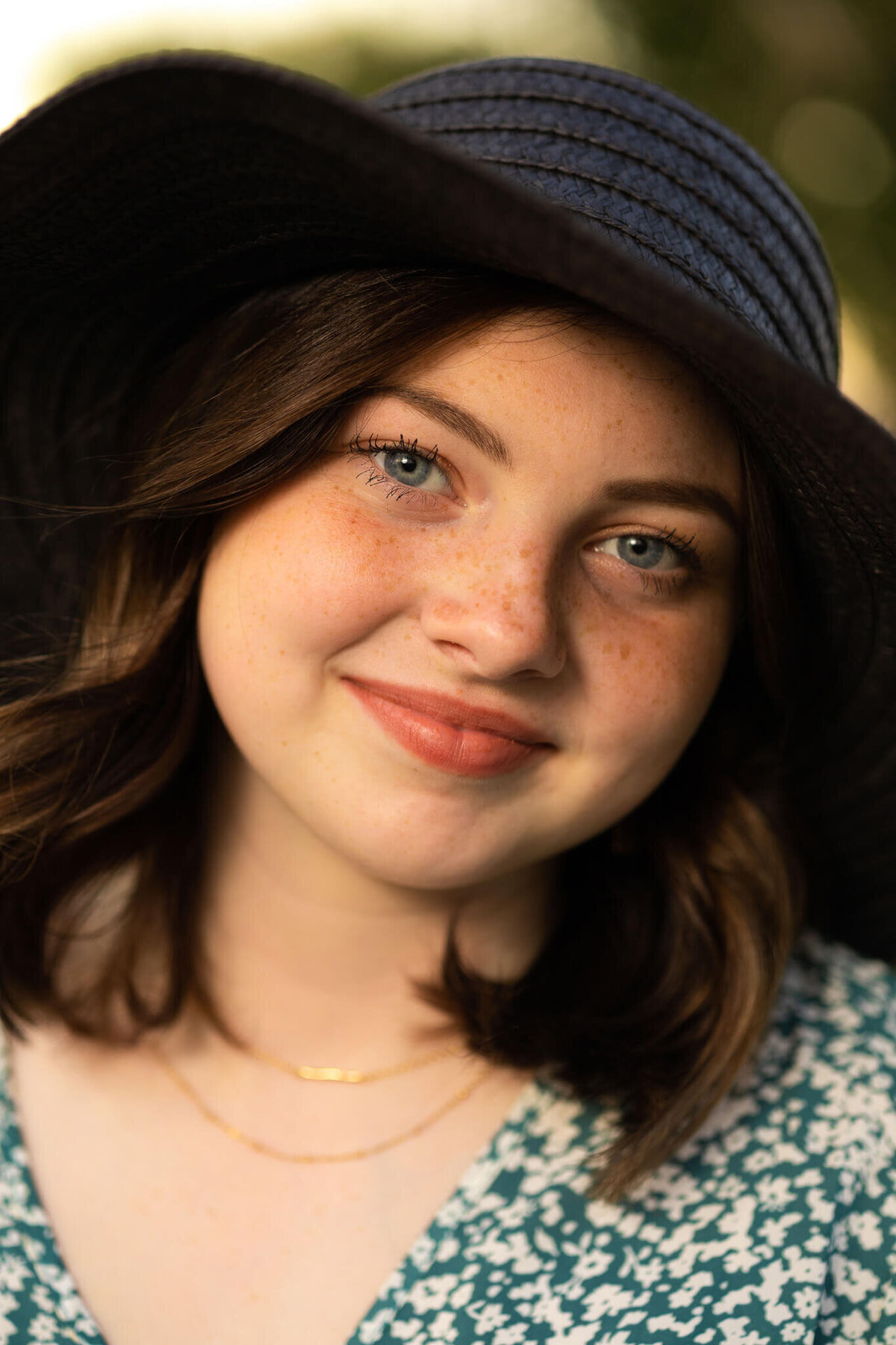 close up of teenage girl in black floppy hat