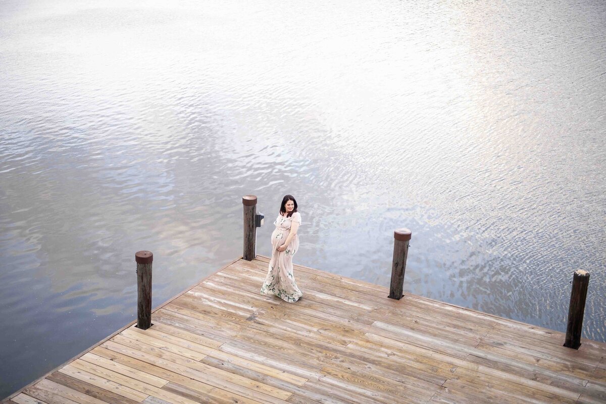 Maternity session of woman posing on pier