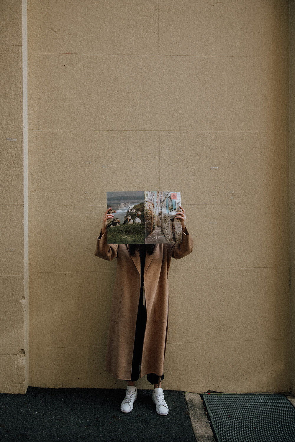 Woman holding a newspaper over her face on a brisbane street