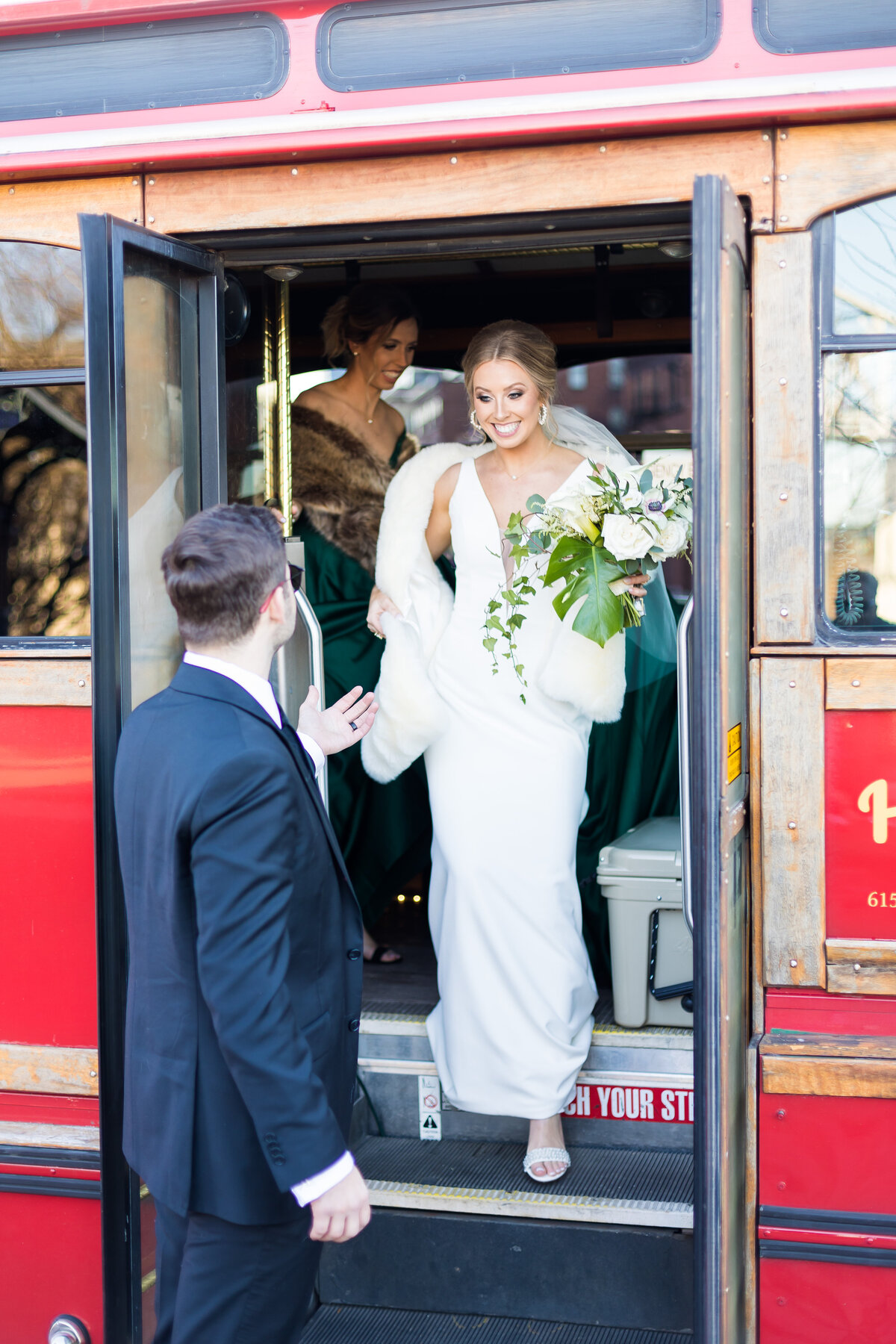 Groom helping bride off the tram at Nashville wedding
