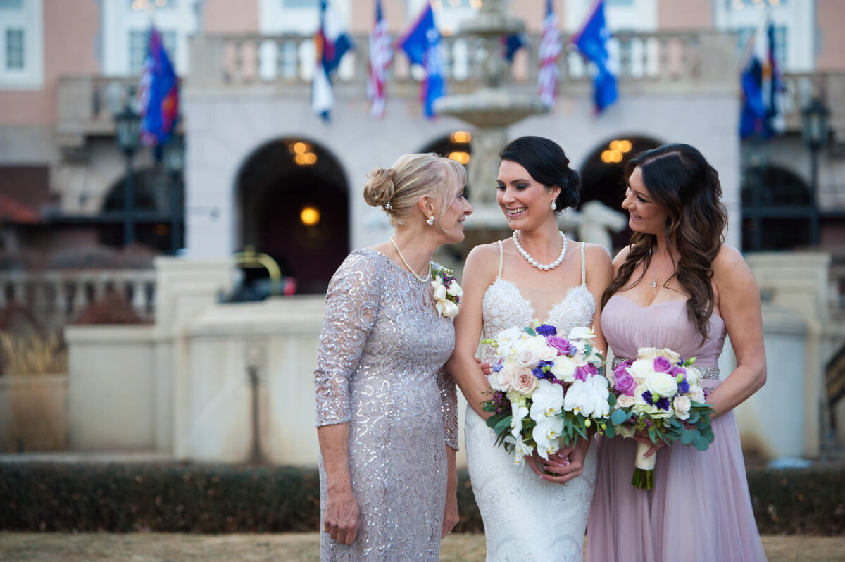 Candid photo of the bride with her mother and maid of honor on the grand lawn at the Broadmoor Hotel in Colorado Springs