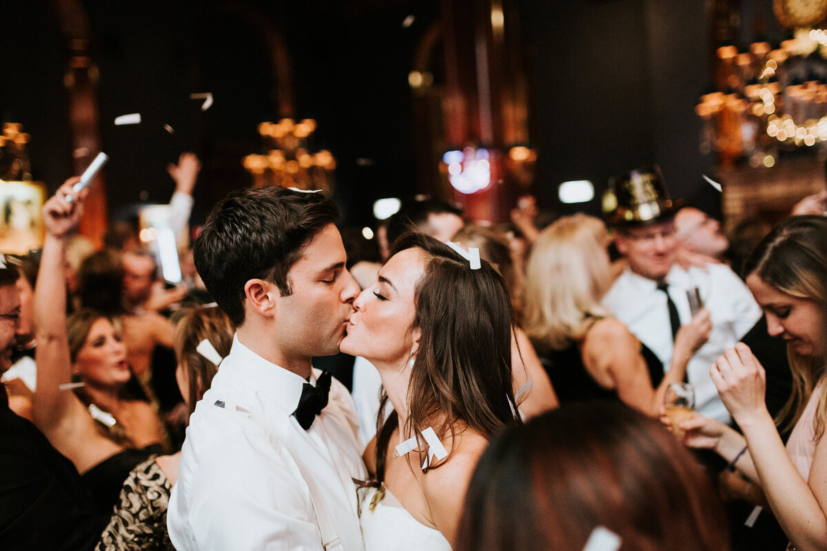 Bride and groom kissing at midnight at New Year's Eve wedding