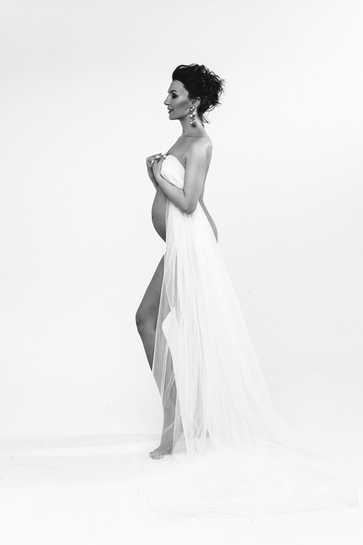 attractive-caucasian-pregnant-female-with-dark-hair-posing-with-white-cloth-her-body