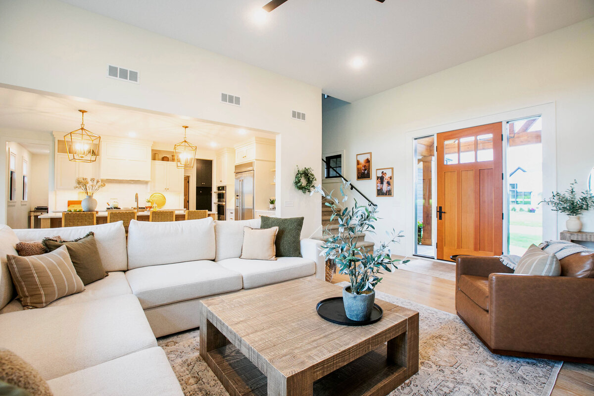 Cozy living room in Otsego custom home with fireplace, built-ins, and large windows
