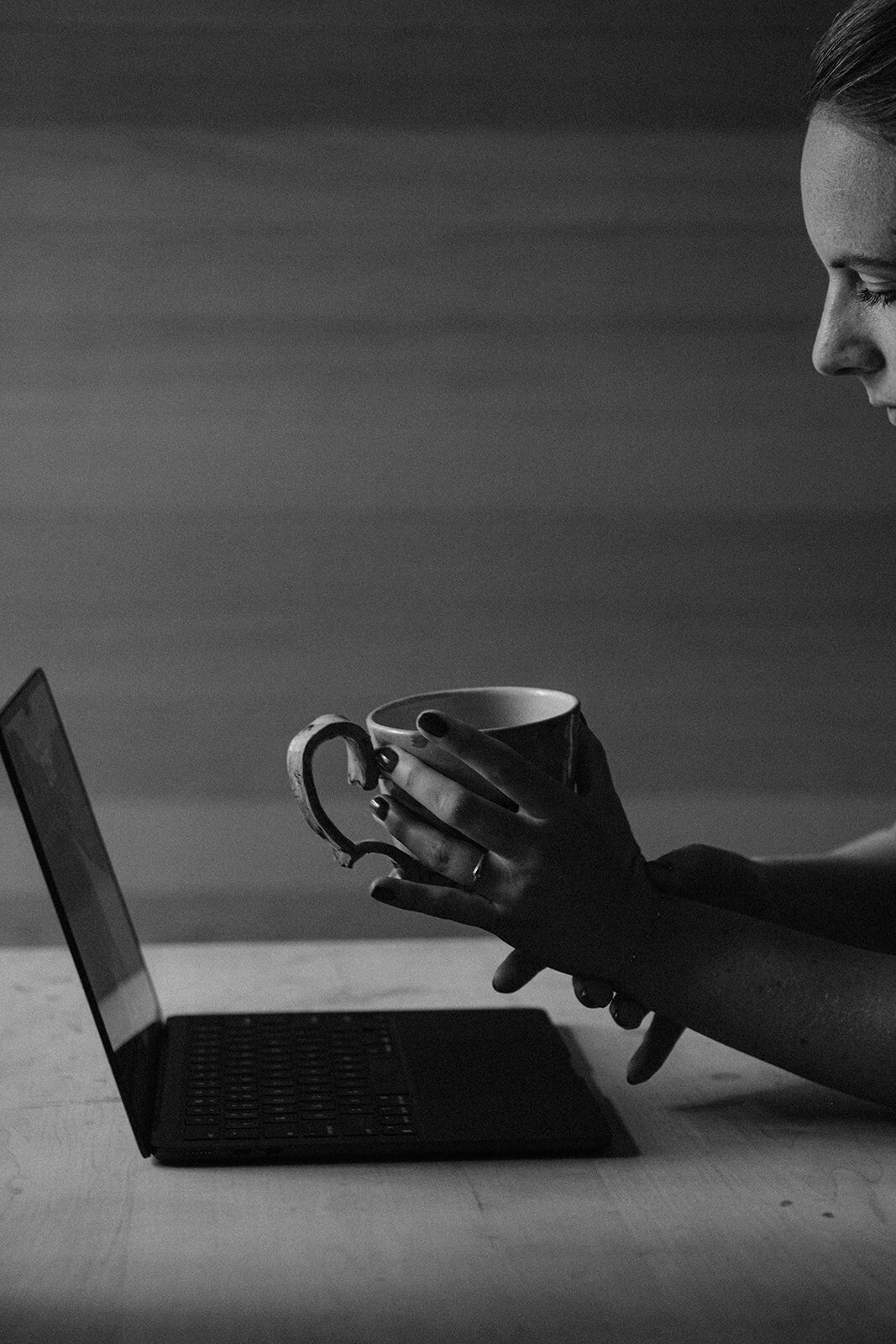 A tea-cup in hand and a laptop