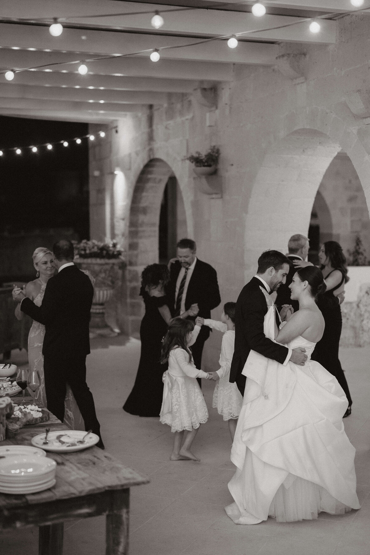 The bride and groom slow dancing with their family and friends