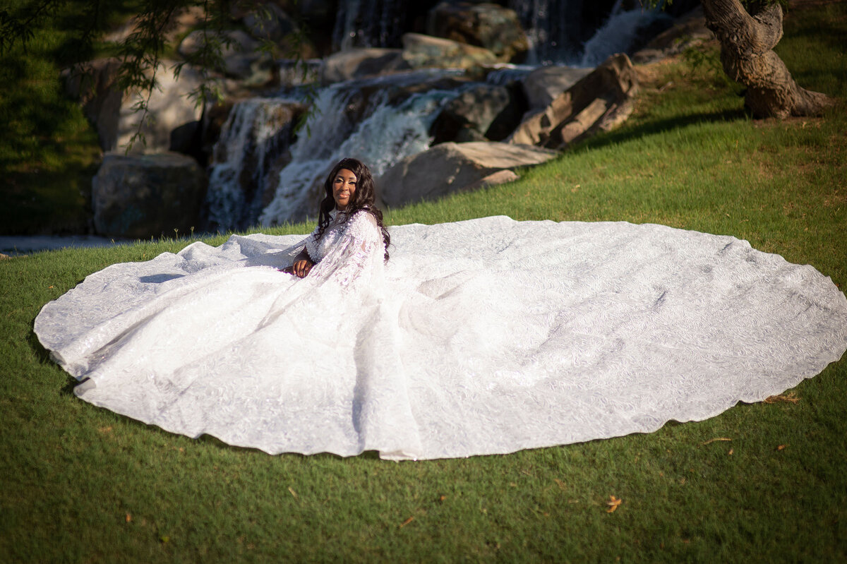 Bride sets in elaborate wedding gown, encircled by its full skirt