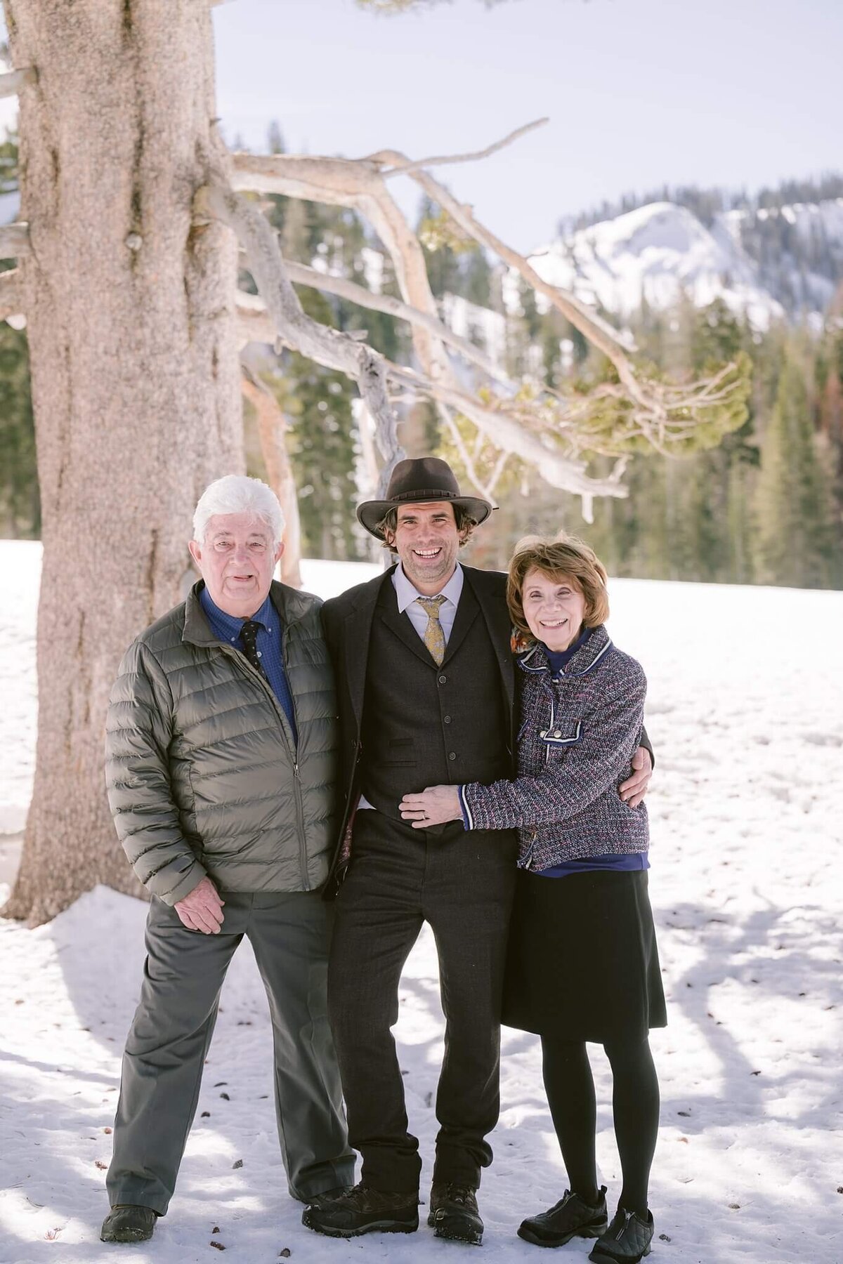 groom posing with his parents during a winter elopemnt in Palisades tahoe