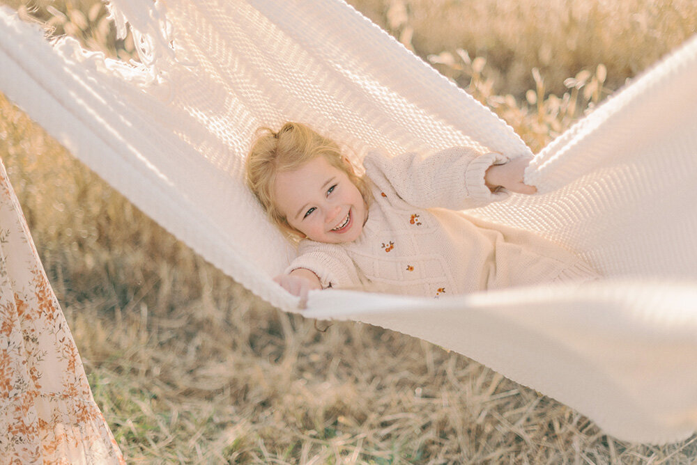 Young girl in a blanket hammock for her Christmas photos