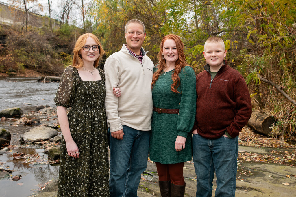 Happy family stands along the water in cuyahoga falls
