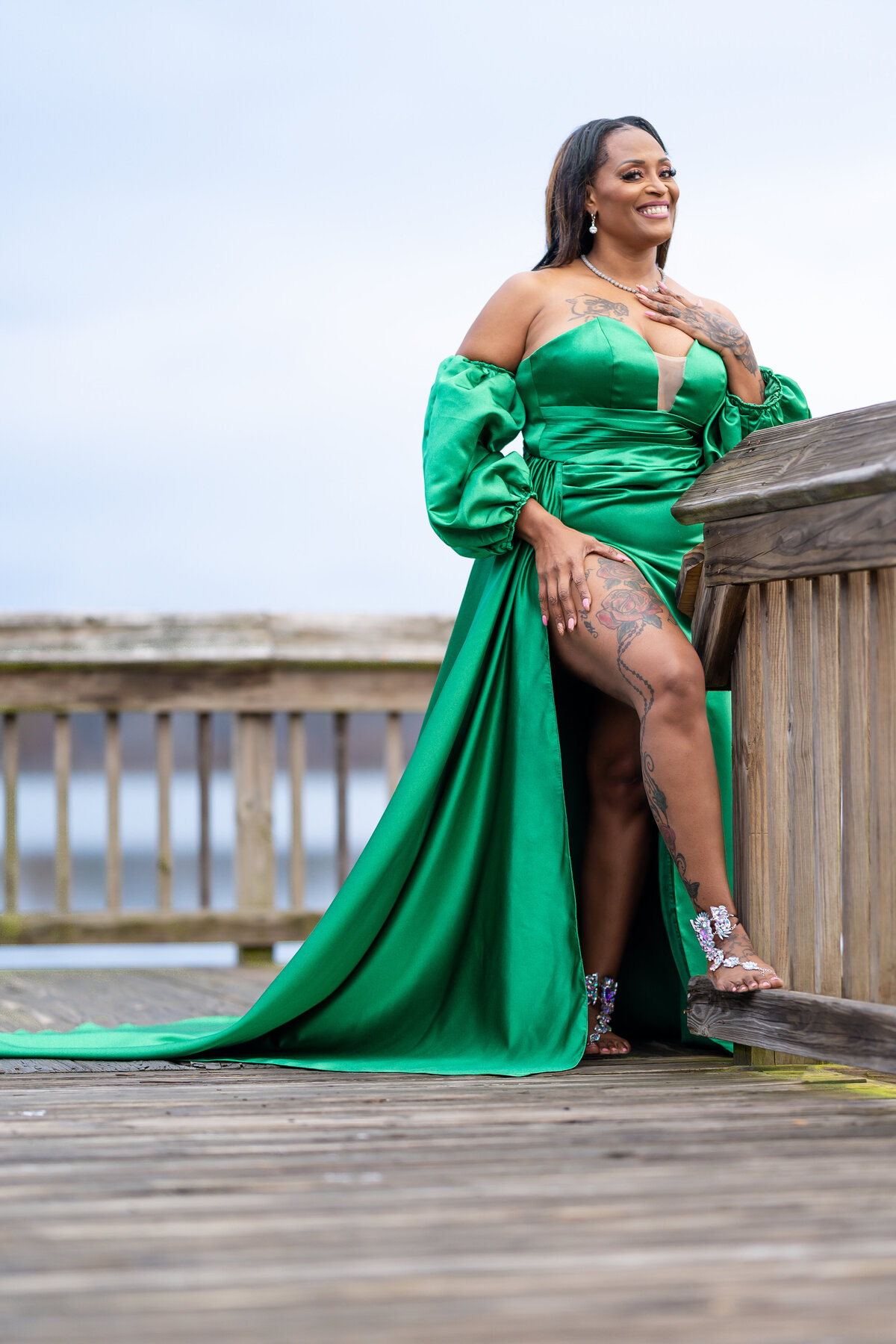 50th milestone birthday photoshoot woman wearing green ball gown by a lake