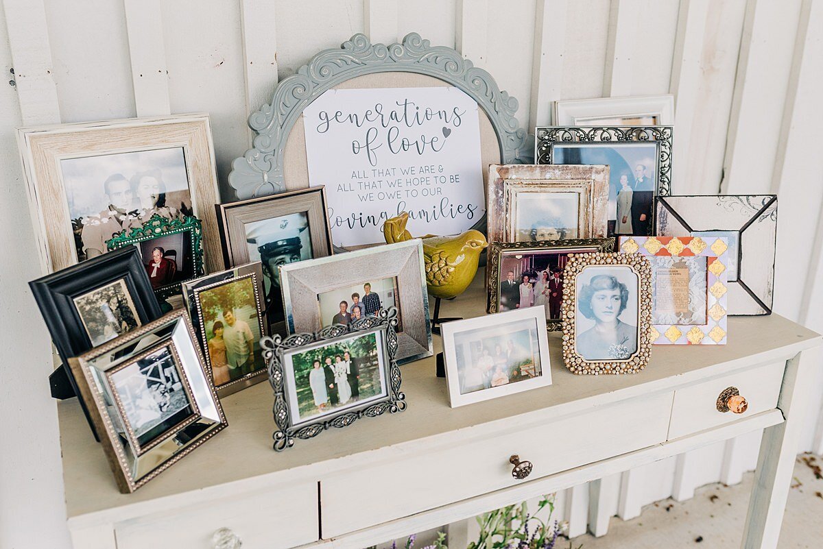 Generations of love wedding memory table on a white table with three drawers and gold drawer pulls. Assorted picture frames with deceased relatives at wedding.