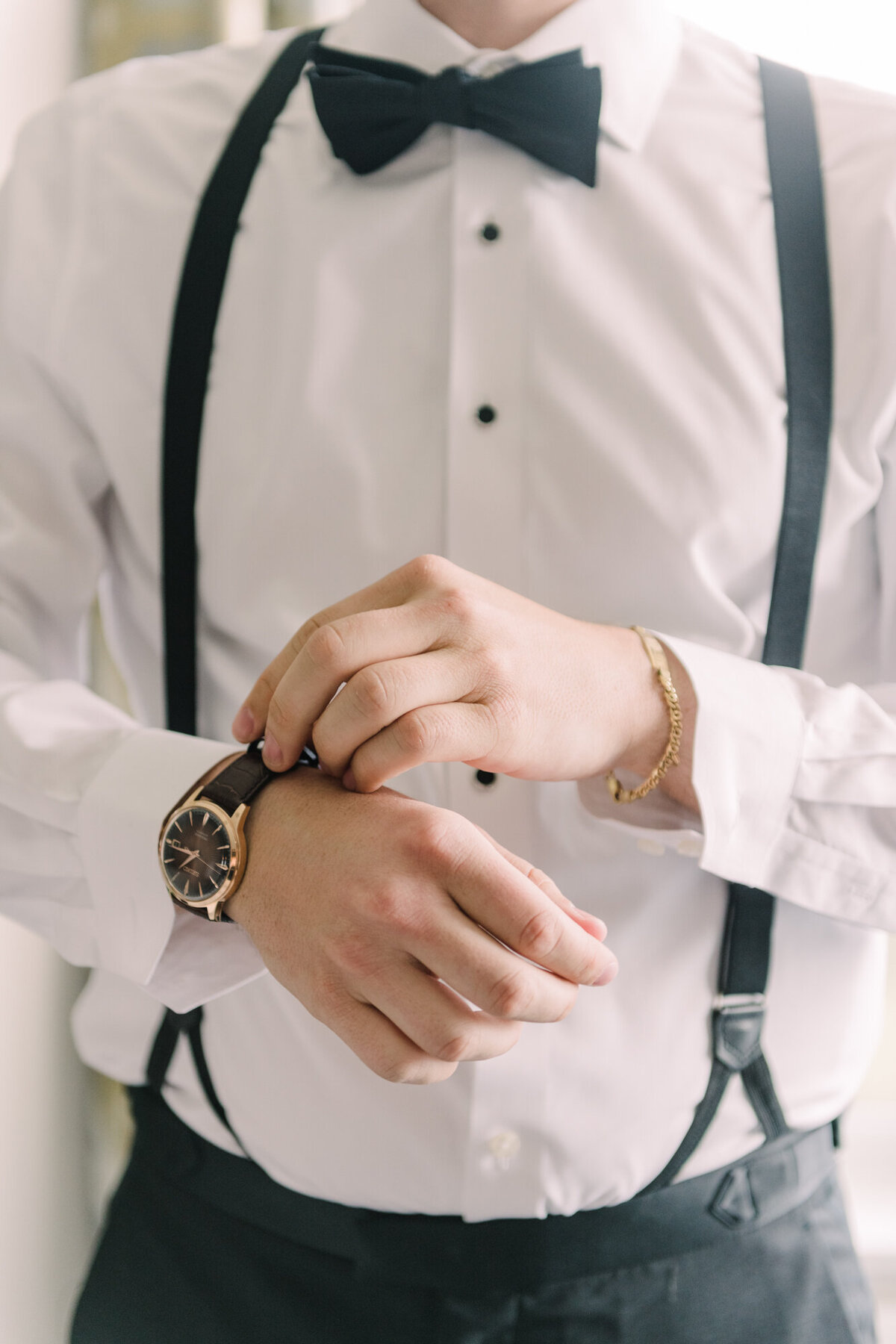 A stylish close-up of a groom adjusting his cufflinks before the wedding ceremony.