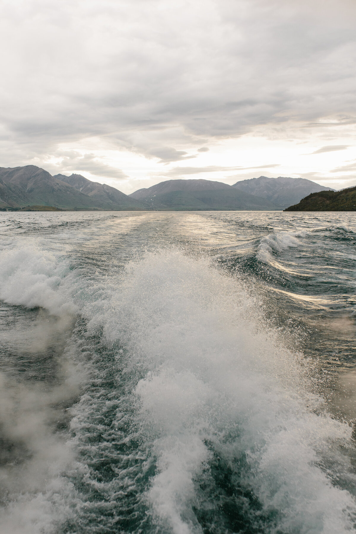 The Lovers Elopement Co - wake of boat looking towards mountains on Queenstown lake Wakatipu