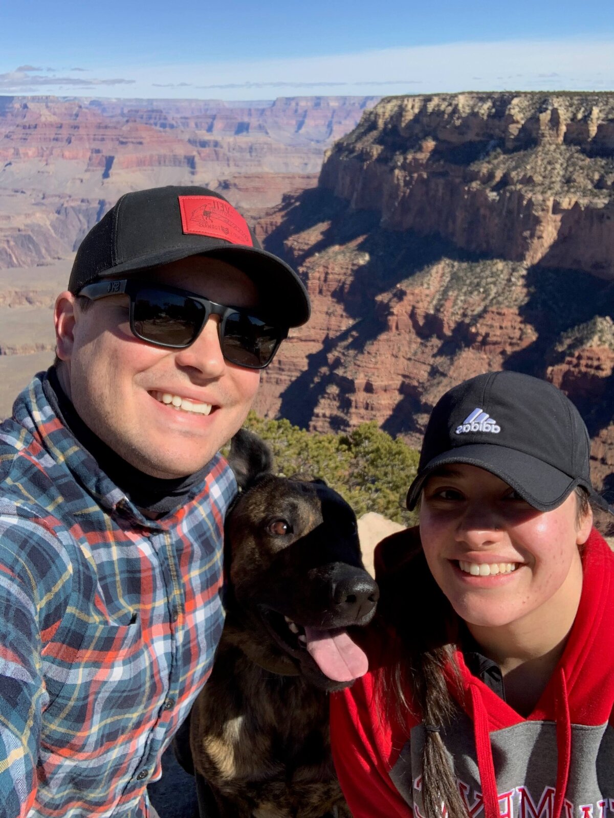 owner as a smiling couple with husband and dog at Grand Canyon overlook