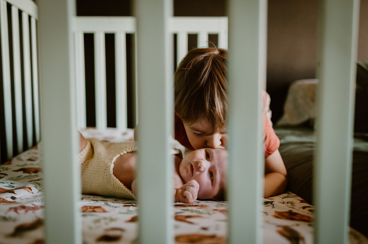 Toddler kissing sibling