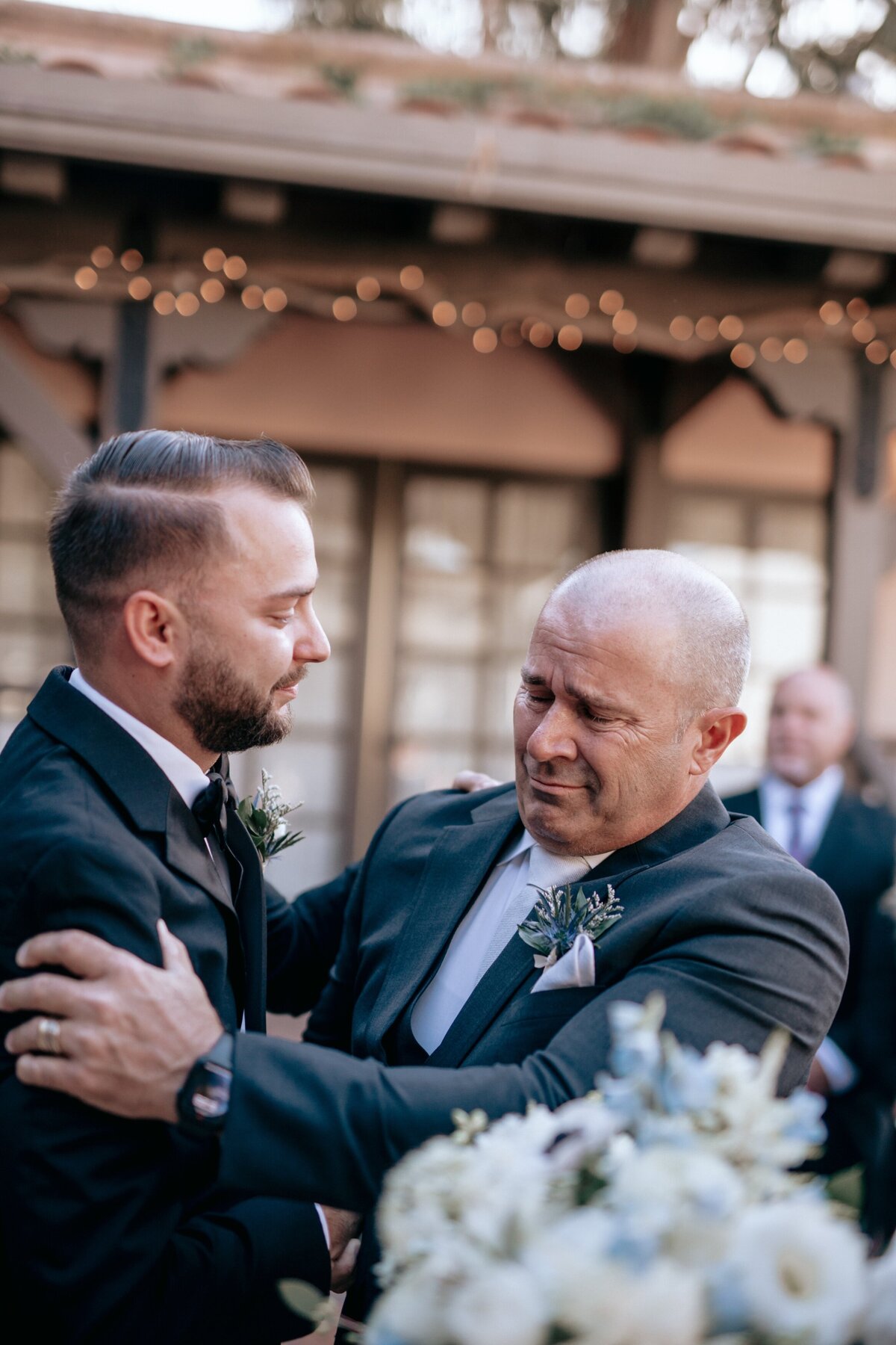 Father and Son embracing at a wedding.