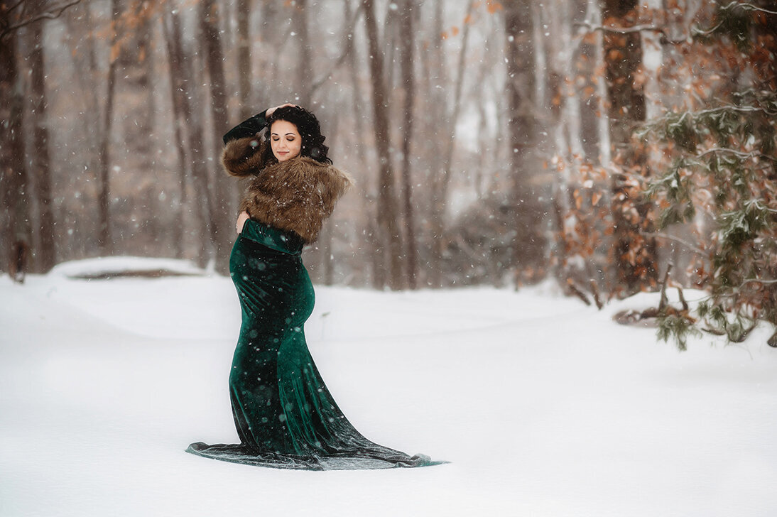 Expectant mother poses for Maternity Portraits in the winter snow in Asheville, NC