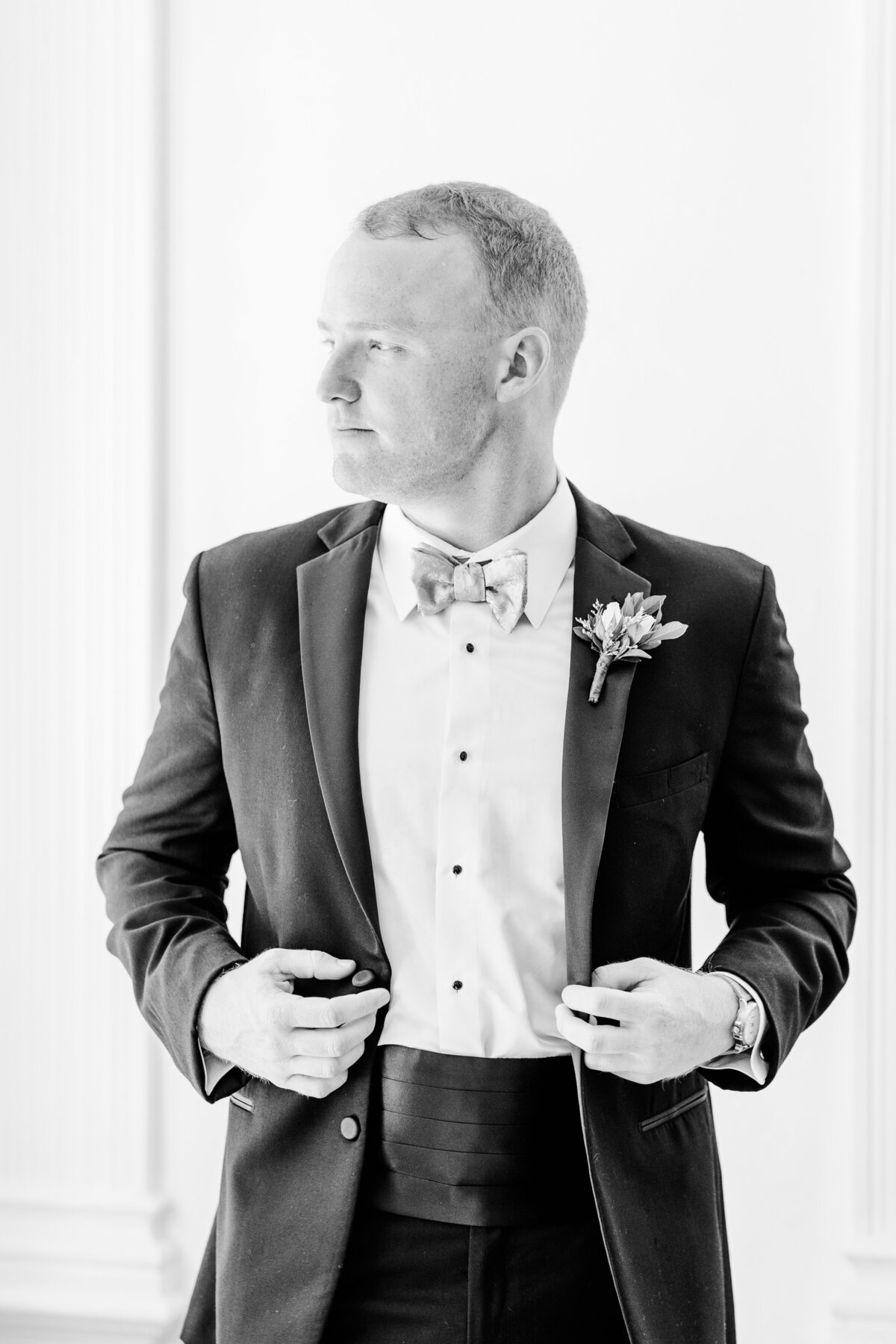 groom adjusting his suit before wedding