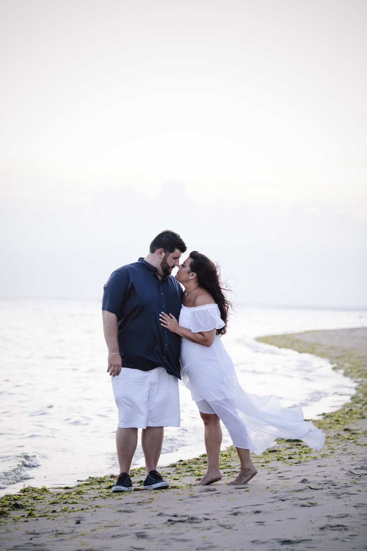 engaged couple walk on beach at sandy hook