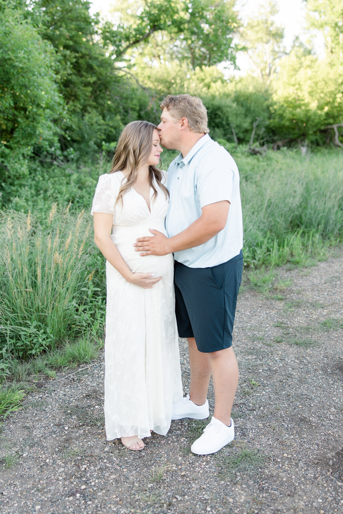 Couple cuddling at sunset holding on to mommas baby bump.