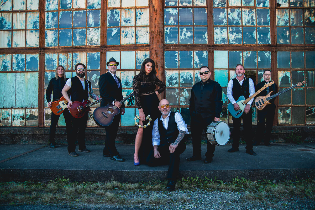 A band standing outside holding their instruments 