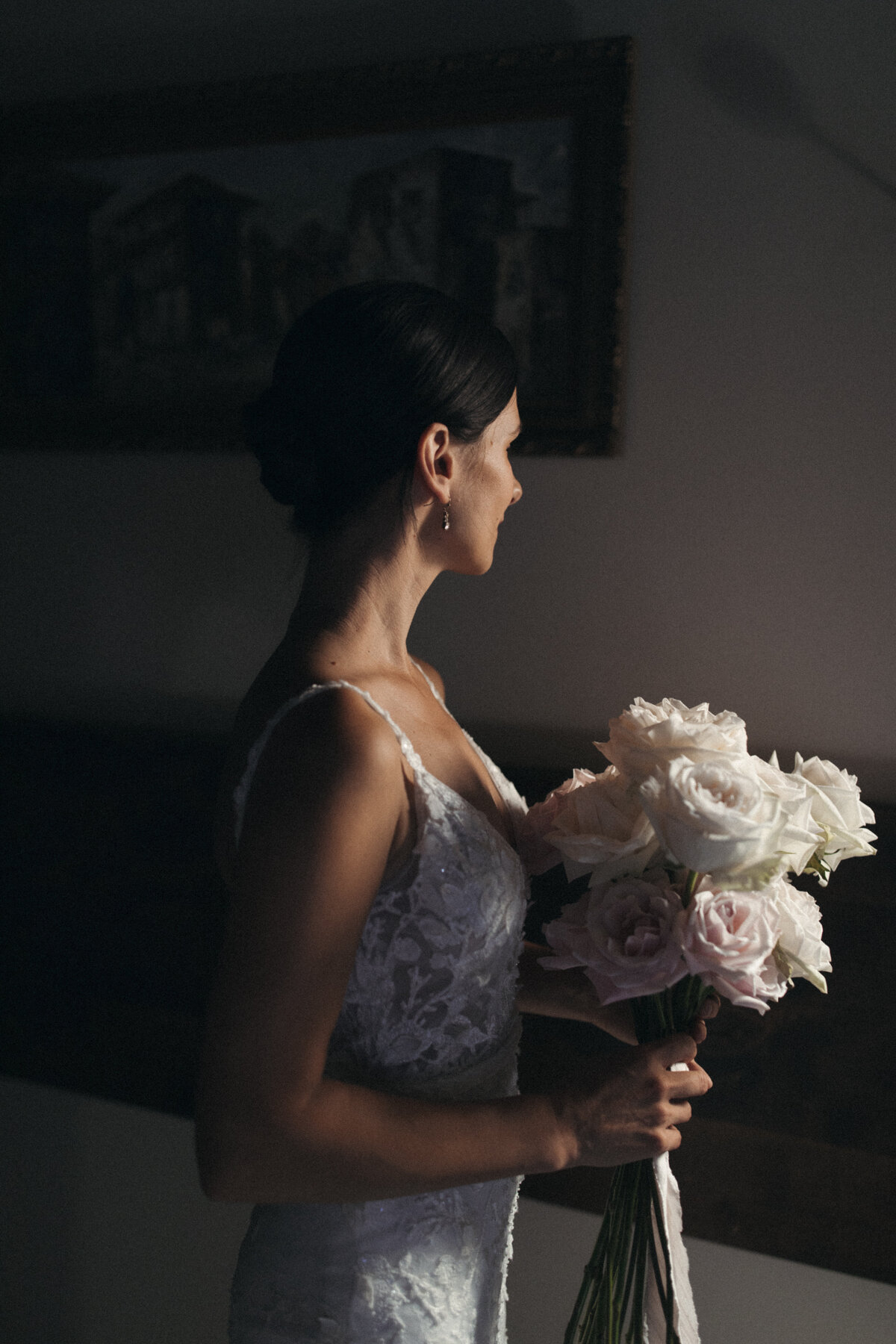 Bride holding long stemmed open white and pale pink roses at Ranch at the Canyons
