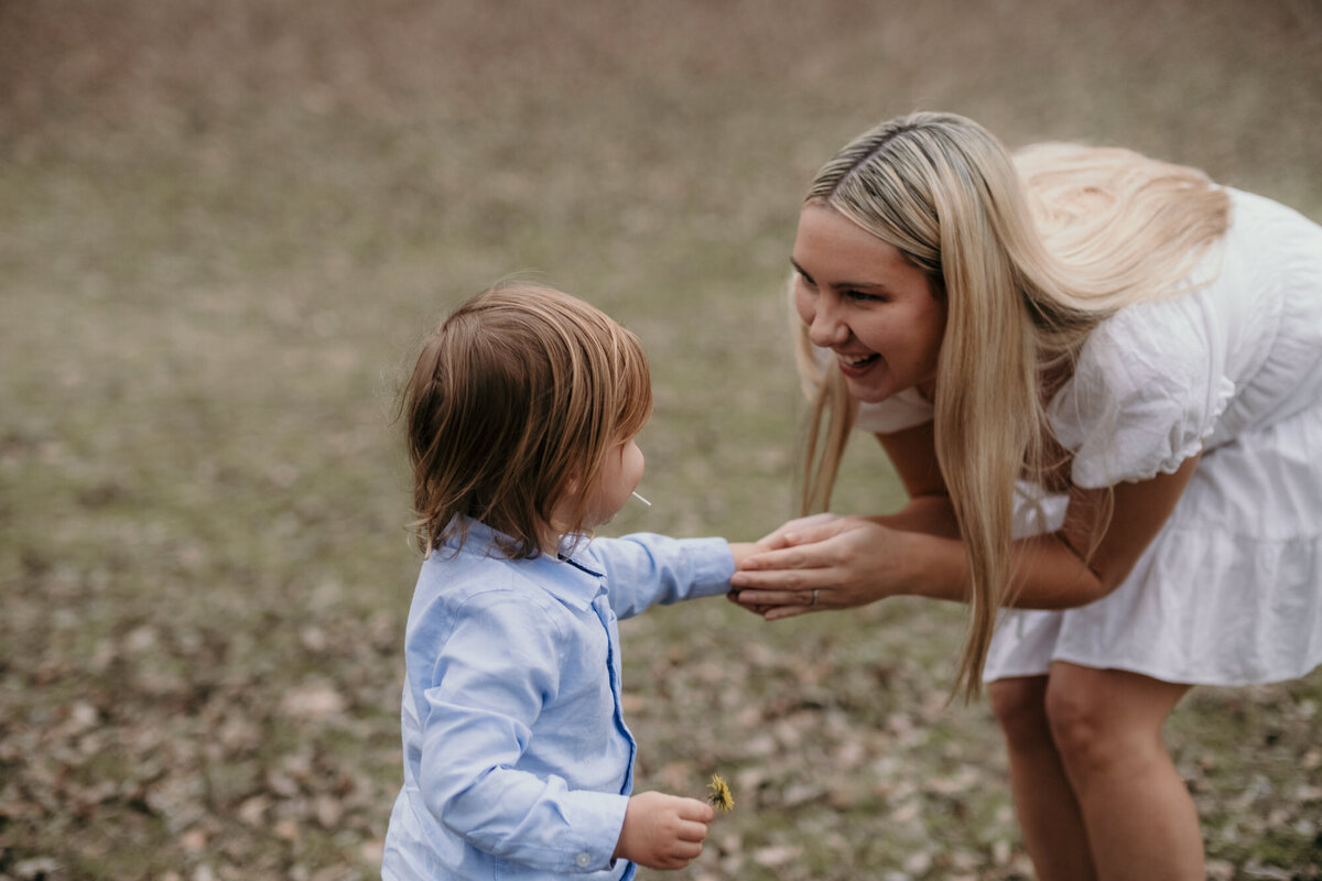 Mom holds her sons hand laughing.