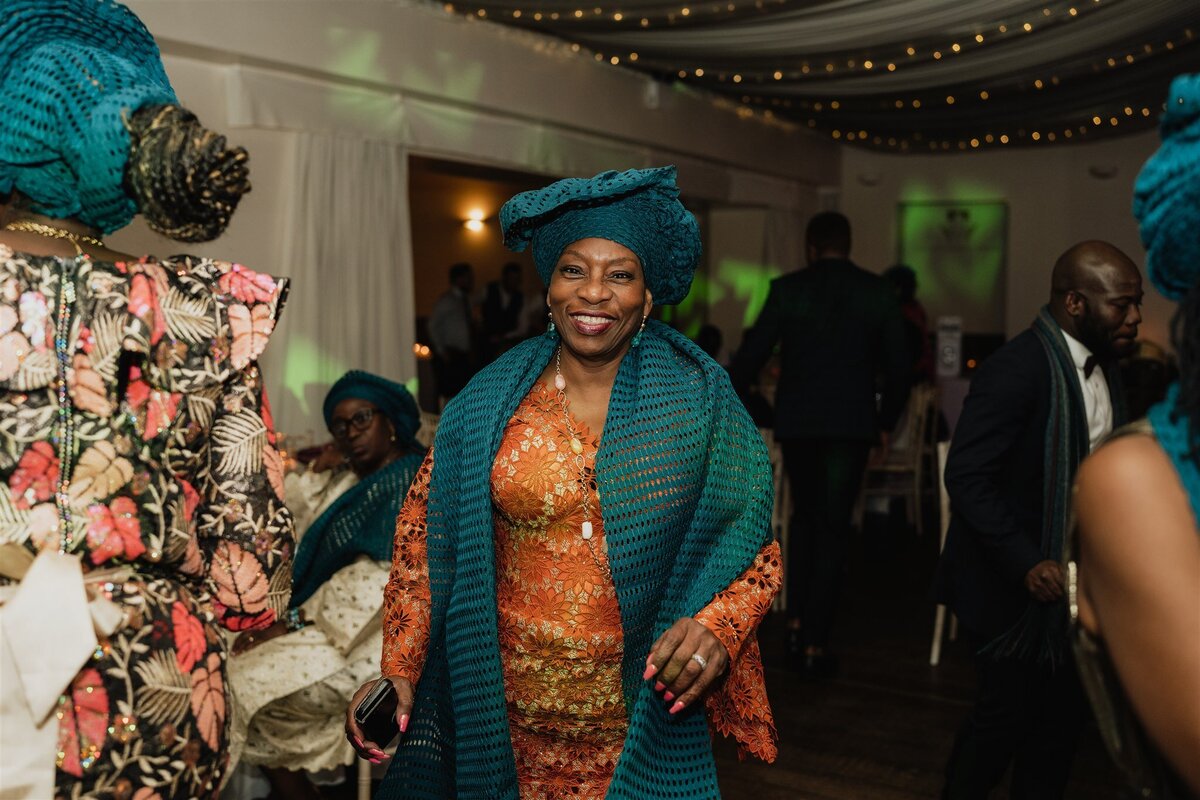 A woman dances at an evening wedding reception. She wears traditional dress.