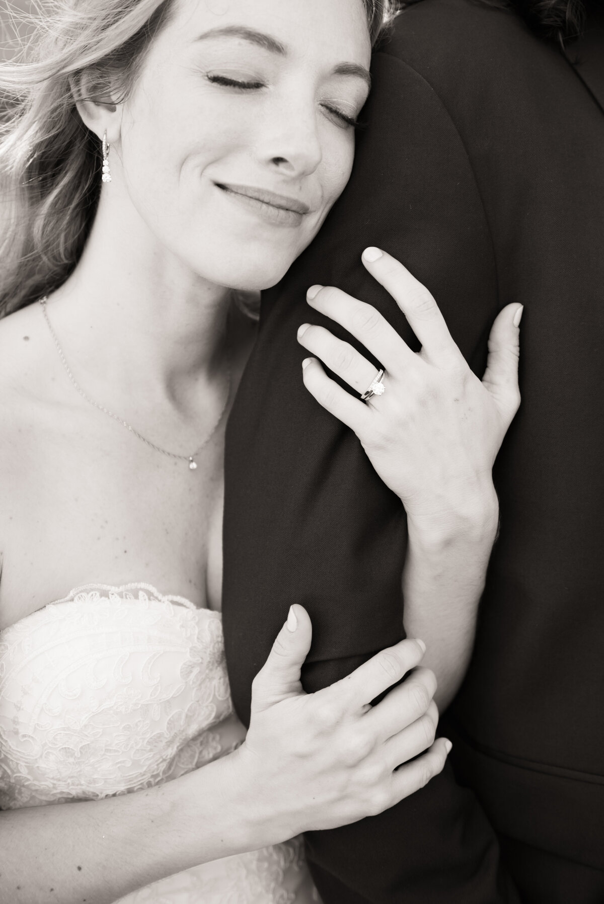 close up of bride's ring while holding grooms arm