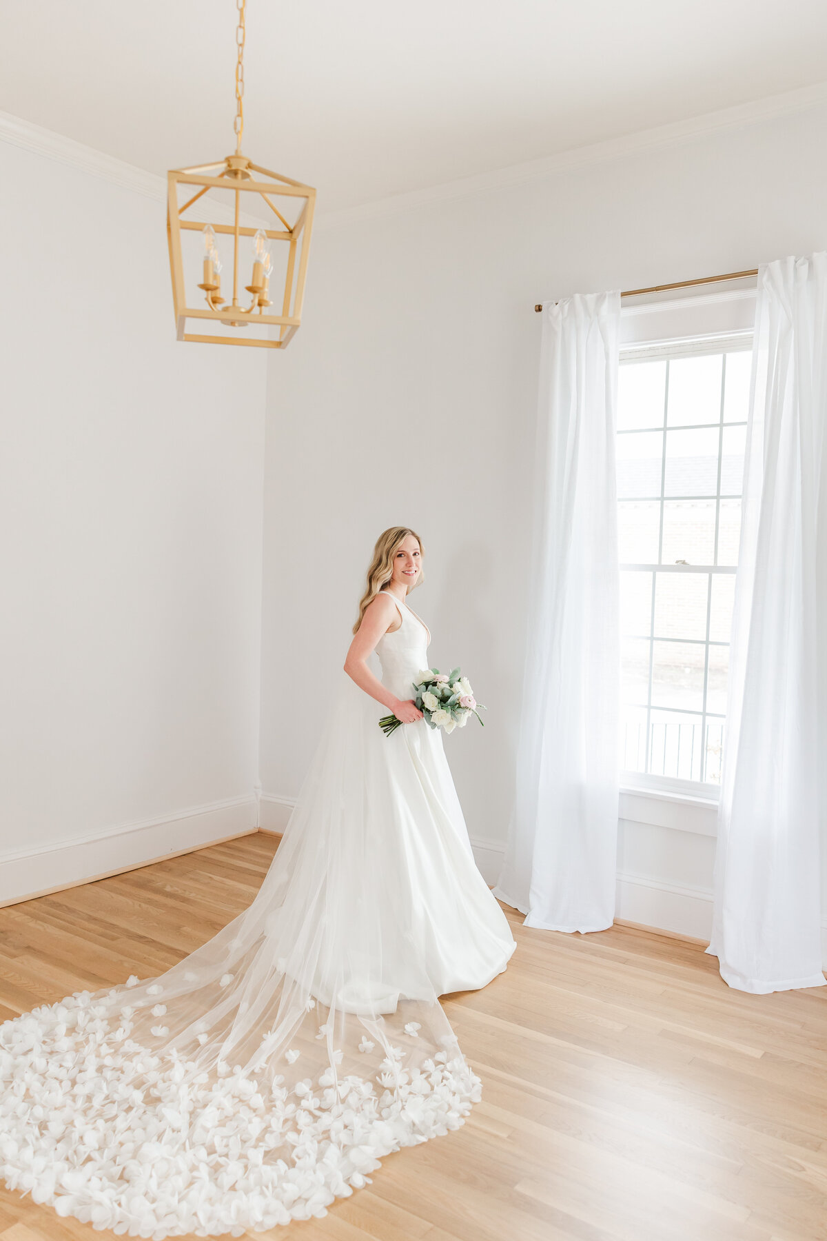 a bride posing for portraits by a window