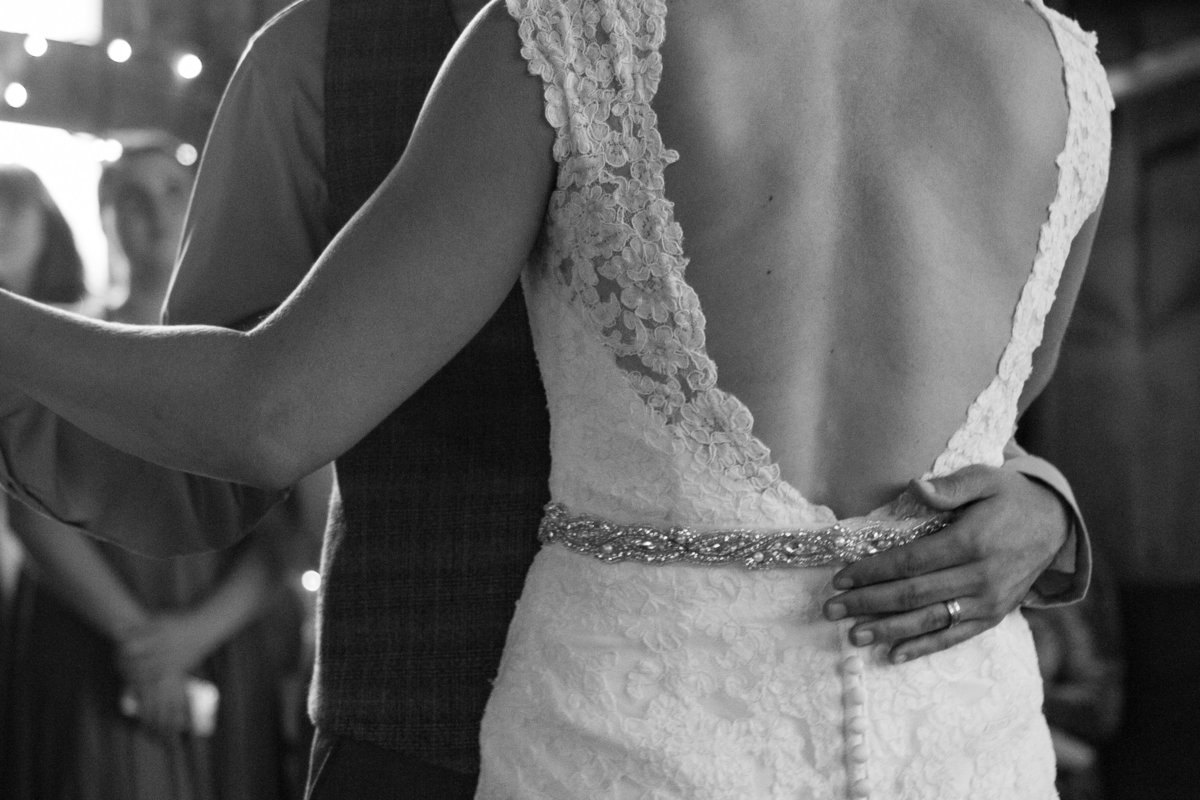 grooms hand on brides waste