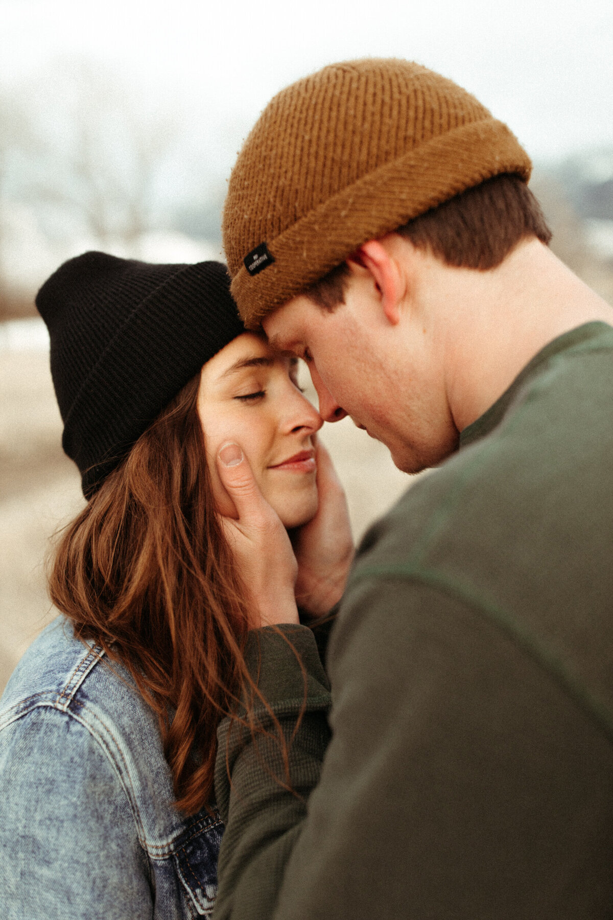 Couple wearing beanies holding each other close