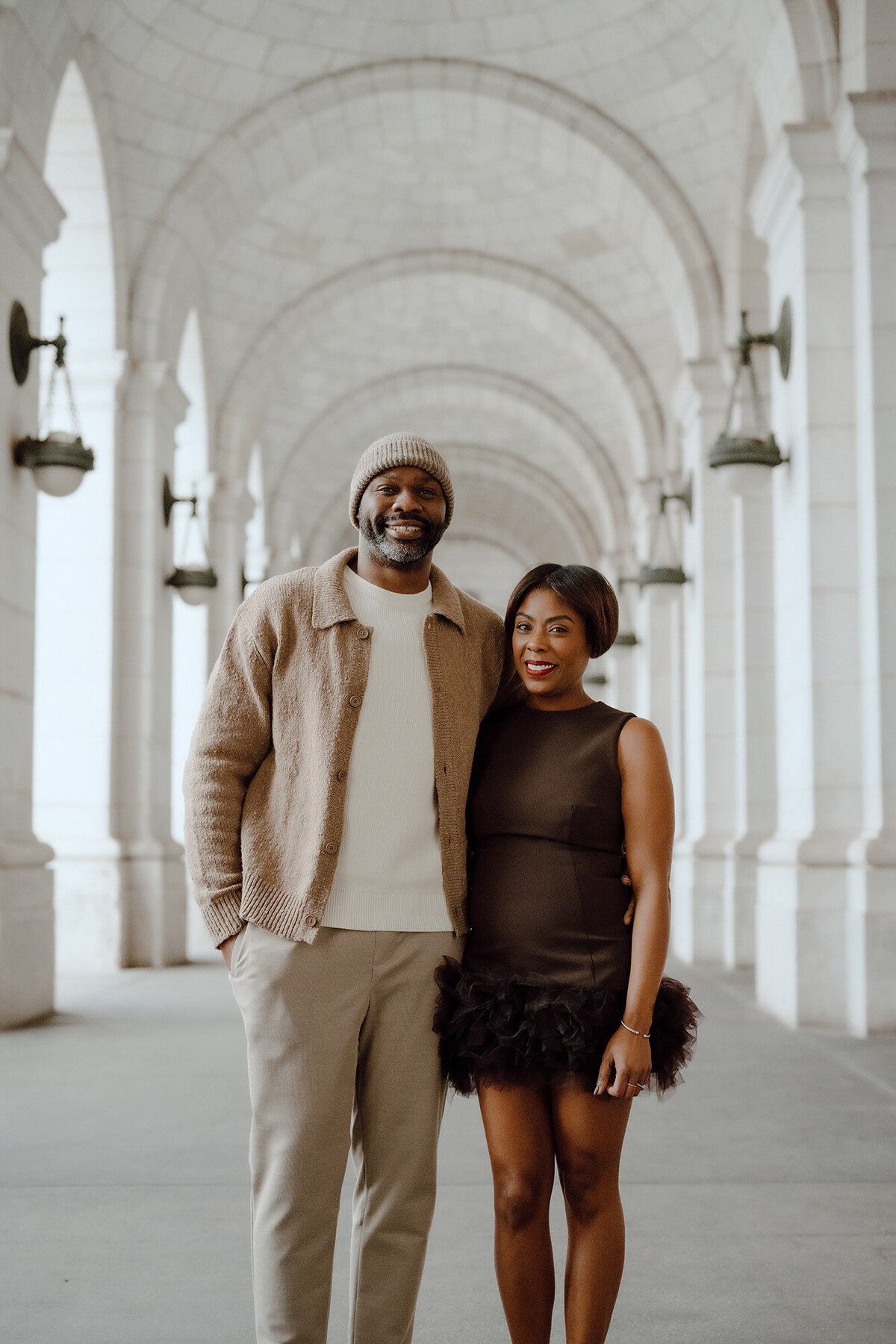 Couple posing under an archway 