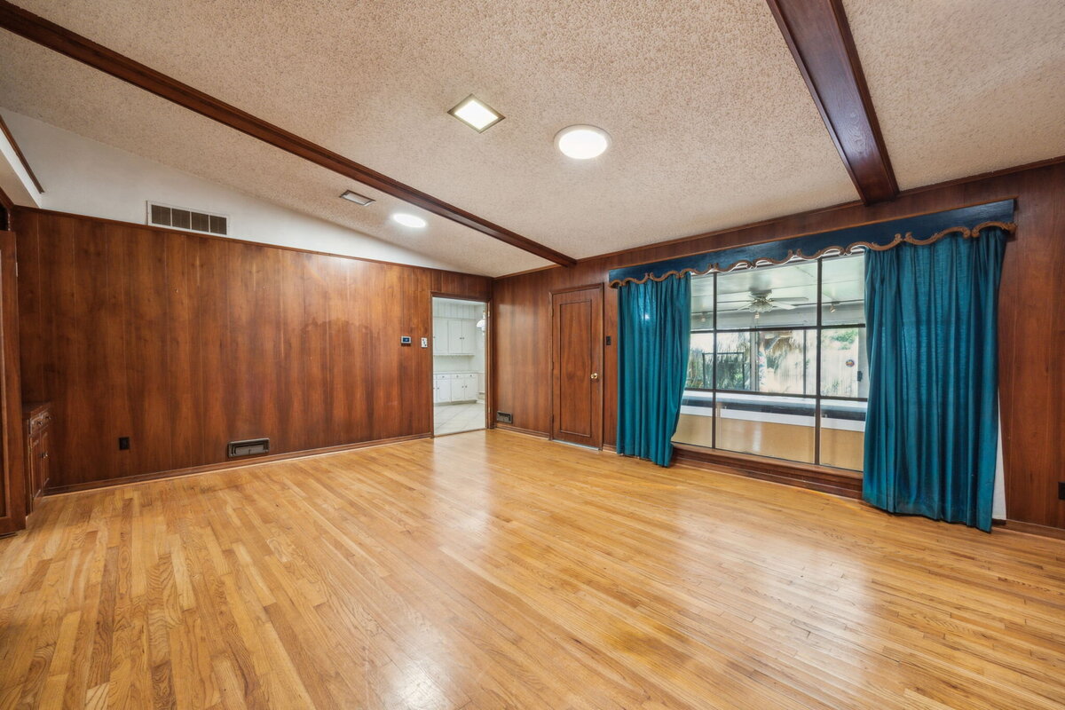 14214_edgecrest_dr_dallas_tx_family_room_view_-wood_paneling_and_large_window_overlooking_sunroom-_haven_realty_group
