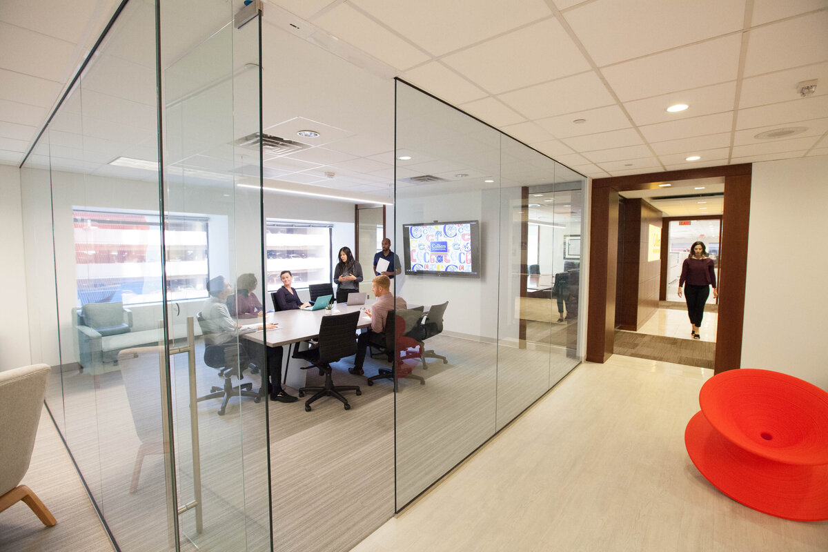 glass conference room with people meeting at a table