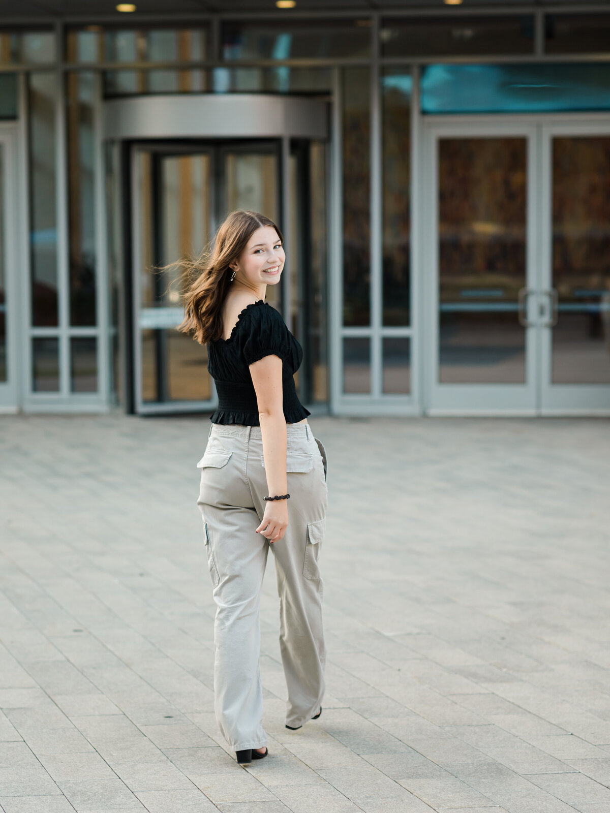 senior girl in black shirt walking in cleveland for senior portraits