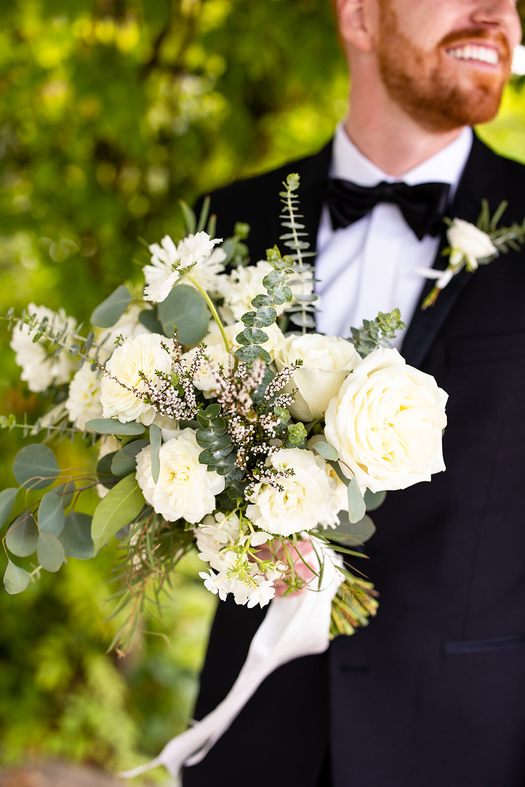Groom with bouquet by Camas Designs