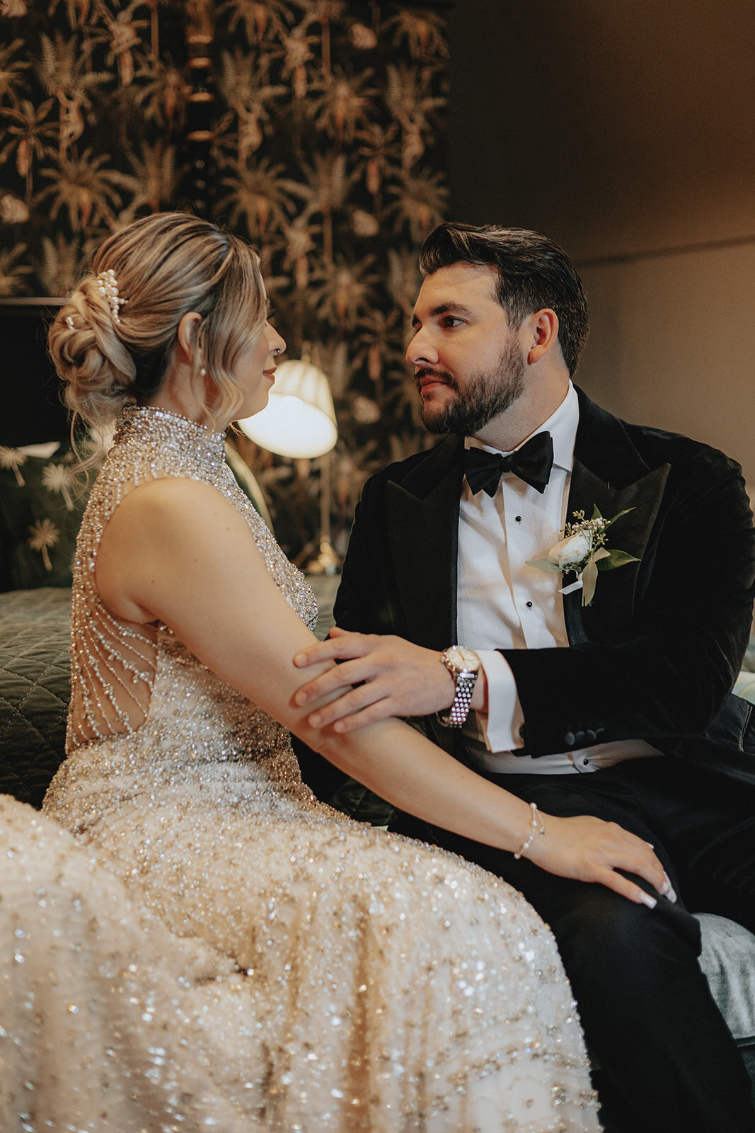 Groom holding bride's arm looking in her eyes