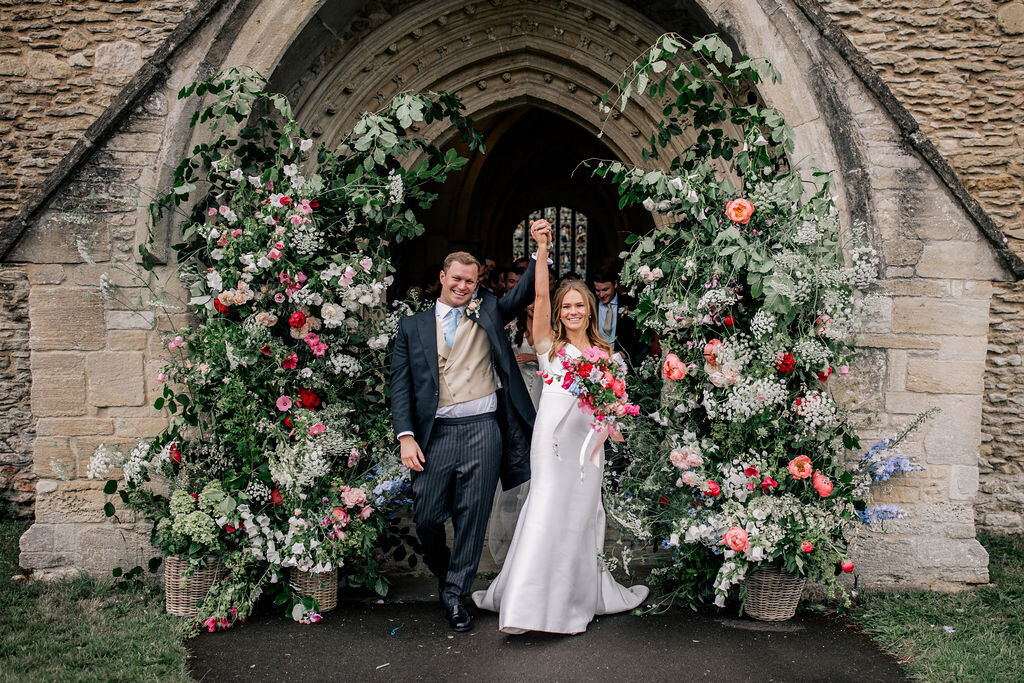 Bride and Groom outside the church with an archway 