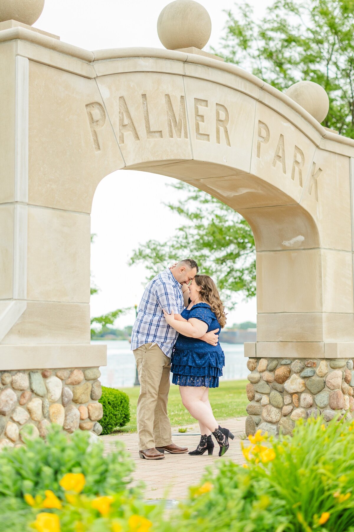 guy and girl facing each other while cuddling under palmer park arch