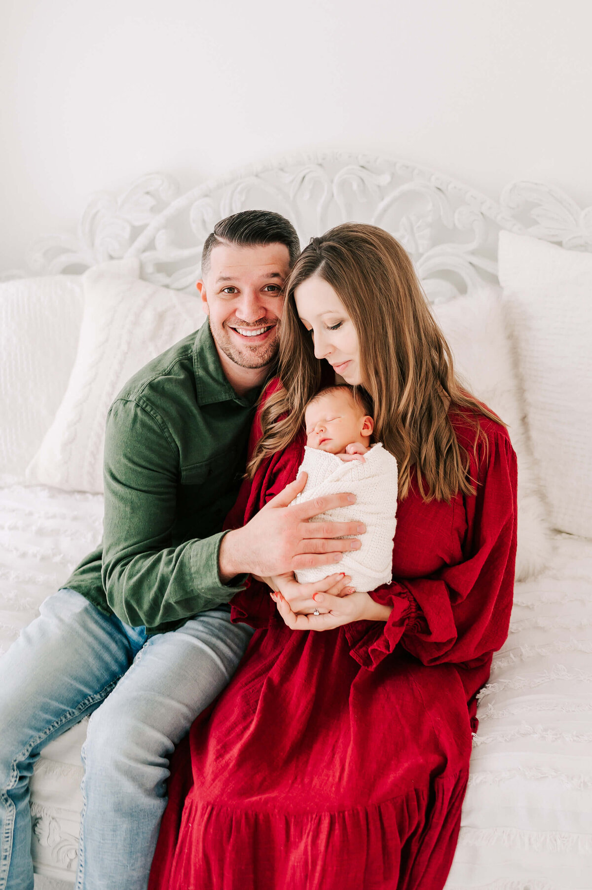 dad smiling cuddling wife and baby in Springfield MO newborn photography studio